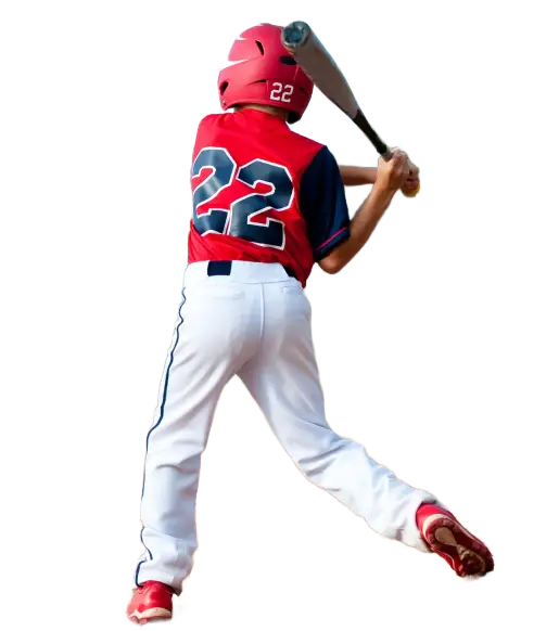 A young baseball player in a red jersey and white pants prepares to hit a ball, bat raised, on a sunny field
