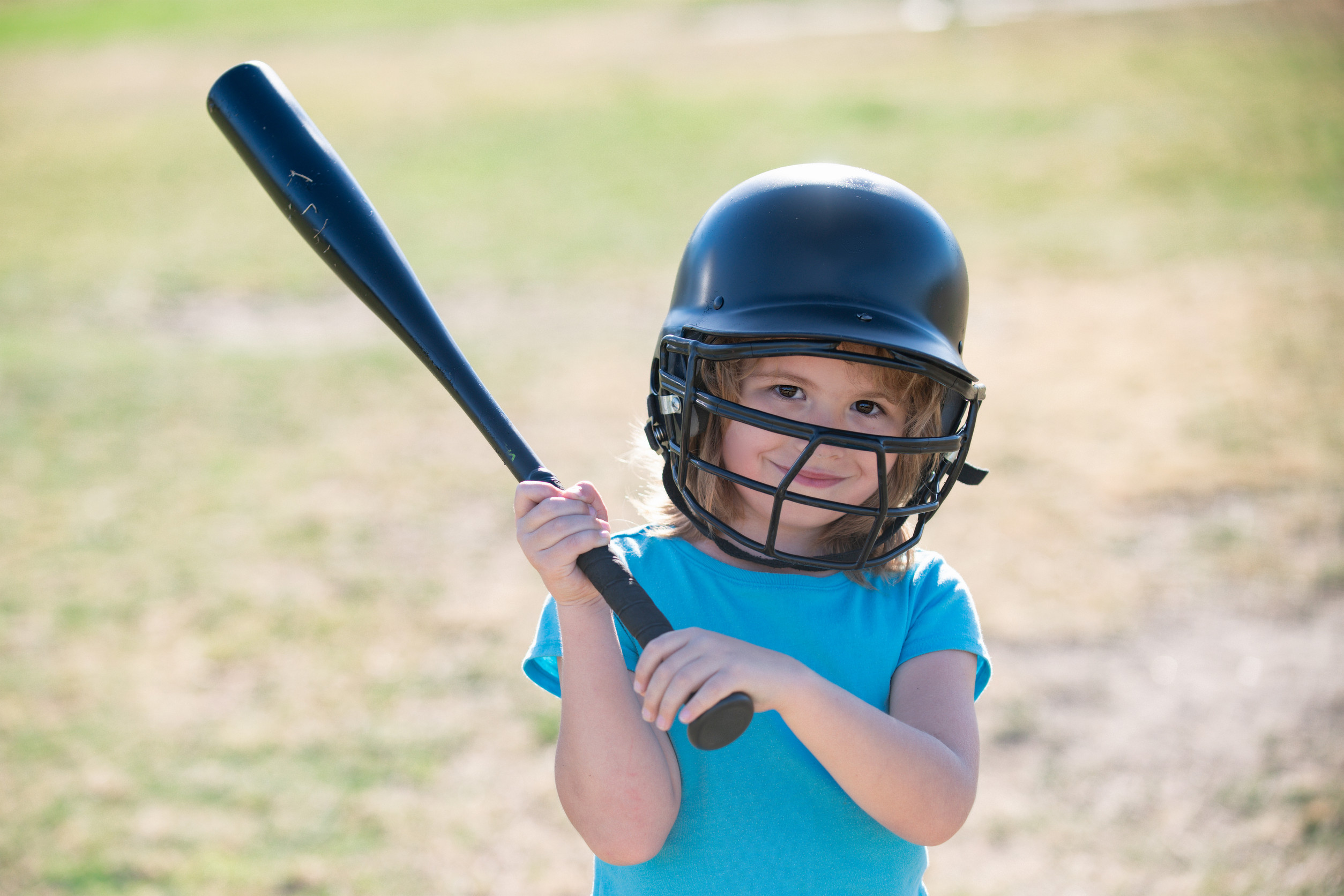 Baseball kid players in helmet and baseball bat in action
